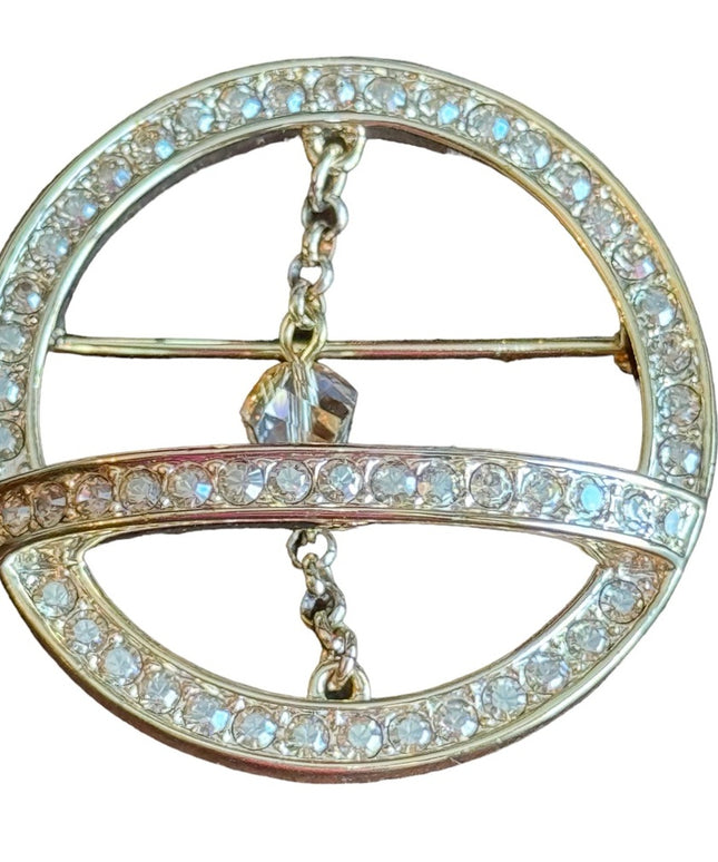 Swarovski gold circle brooch a pave of clear crystal and features a small chain